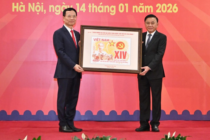 Minister of Science and Technology Nguyen Manh Hung presents the postage stamp set “Celebrating the 14th National Congress of the Communist Party of Viet Nam” to Permanent member of the Secretariat Tran Cam Tu.